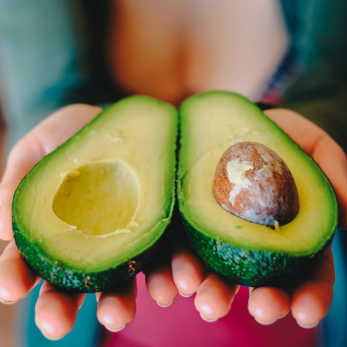 Avocado tagliato a metà, simbolo di ingredienti naturali nei cosmetici